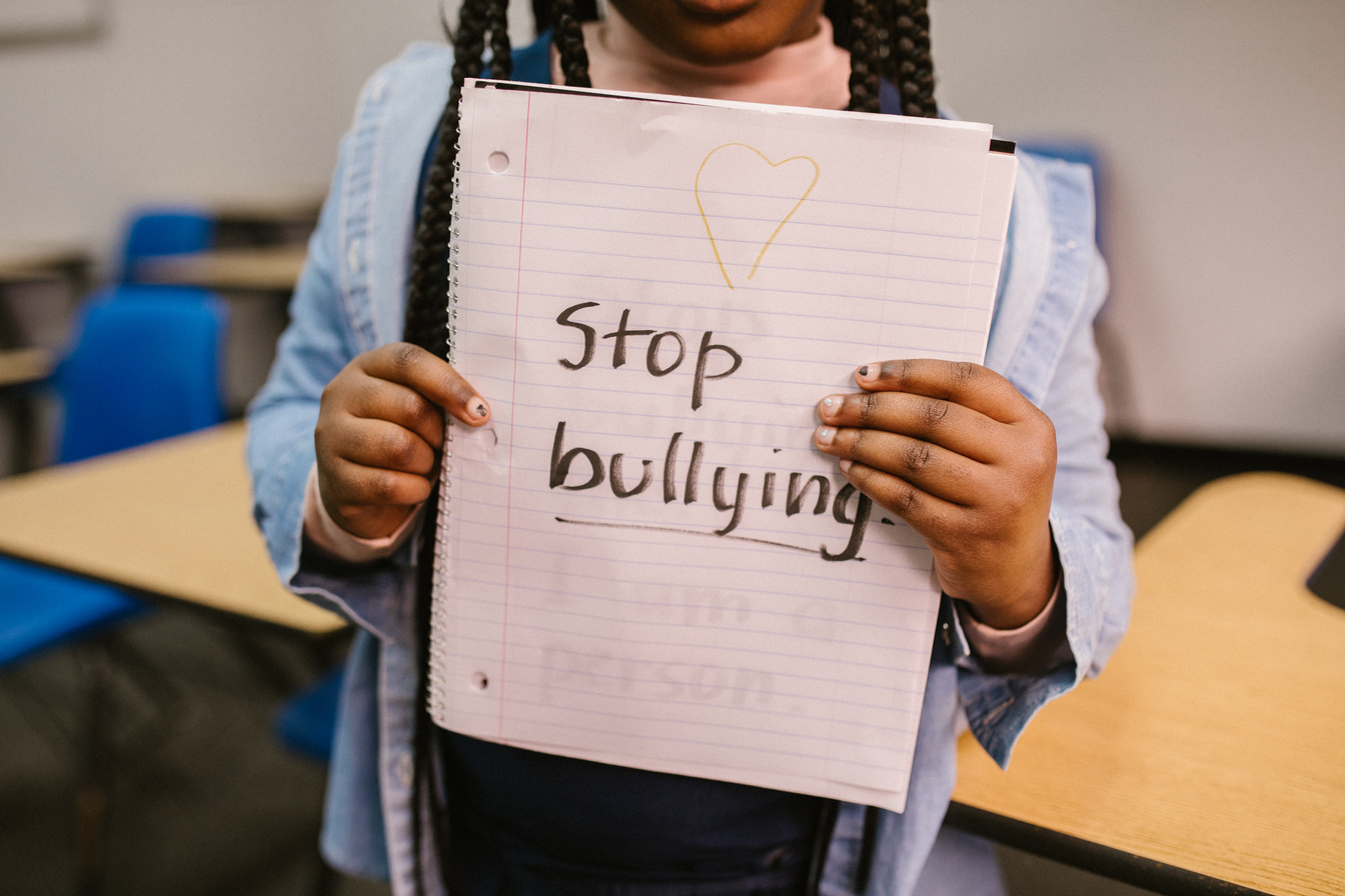 Girl Holding a Notebook with Stop Bullying Text 